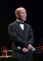 Joe Hisaishi on stage at a concert