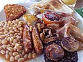 Image 48The full breakfast is among the best known British dishes, consisting of fried egg, sausage, bacon, mushrooms, baked beans, toast, fried tomatoes, and sometimes white or black pudding. (from Culture of the United Kingdom)