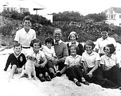 Family portrait taken outside with children surrounding their parents