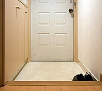 The same genkan, viewed from inside looking out. The doors on the left wall are getabako.