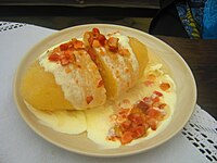 Large cepelinas served with pork rinds