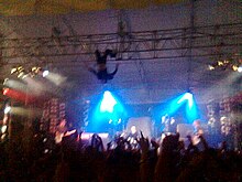 Kody Nielson hangs upside down over the stage during a performance at Auckland University of Technology