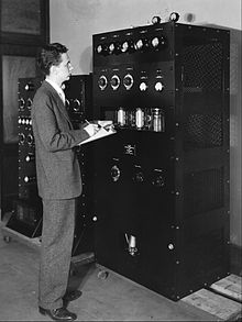 Aurthur A Collins standing next to a transmitter.