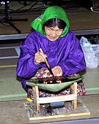 An Inuk woman tending a qulliq, a traditional whale, or seal, oil lamp (Nunavut, Canada, 1999)