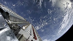 A batch of small satellites attached to the rocket with the Earth in the background