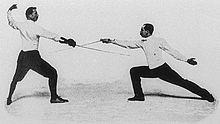 Photo de deux hommes pendant un combat d'escrime.