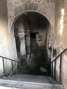 escalier menant dans une pièce à colonnes