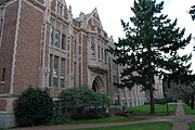 The facade of an imposing Gothic revival university building clad in brick and stone