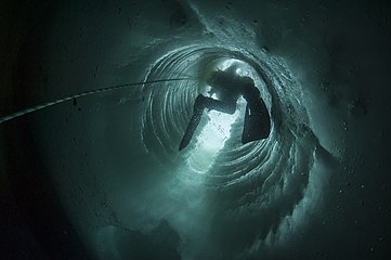 Plongeur scientifique polaire à la Base antarctique Dumont-d'Urville, photographié à l'intérieur d'un tube de glace, créé selon la technique des forages pétroliers pour permettre l'accès à l'eau. Gagnant de la catégorie « People in Science » en 2017, par Erwan Amice, France