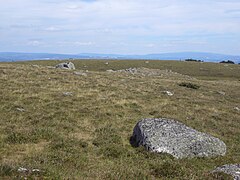 Blocs de granite transportés sur un plateau basaltique dans les monts d'Aubrac (Massif central)