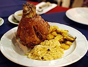 Schweinshaxe served with roasted potatoes (Bratkartoffeln) and Sauerkraut at a Bavarian restaurant in Chiang Mai, Thailand