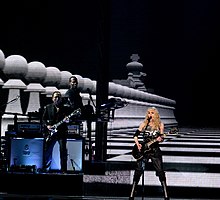 Photographie de Madonna avec une guitare électrique pendant le Sticky & Sweet Tour.