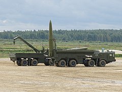 A launcher 9P78-1 of Russian missile system 9K720 Iskander in foreground and a transloader 9T250 in the background