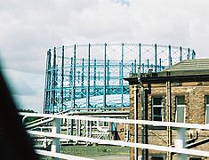 The gasholders of Provan Gas Works, on the skyline in Glasgow, pipework and the booster house can also be seen.