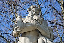 Statue de Saturne devant un ciel bleu, un homme barbu mangeant un bébé.