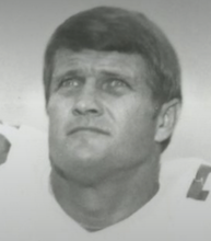 black and white head shot of Neely a light skinned man with short dark hair wearing a football jersey