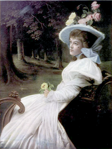 Young white woman, seated, wearing elaborate white hat and flowing summer gown, and holding a yellow rose in her hand, in idealised outdoor scene