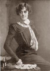 young, dark-haired white woman, seated, wearing late Victorian clothes