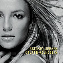 The headshot of a younge blond woman. Her hair is blond and feathered straight. She is wearing lipstick and makeup. Her mouth is slightly open and her hand is pressed against her neck. In the bottom, the words "Britney Spears" are written in yellow italics. Below, the word "Outrageous" is written in the same fashion.