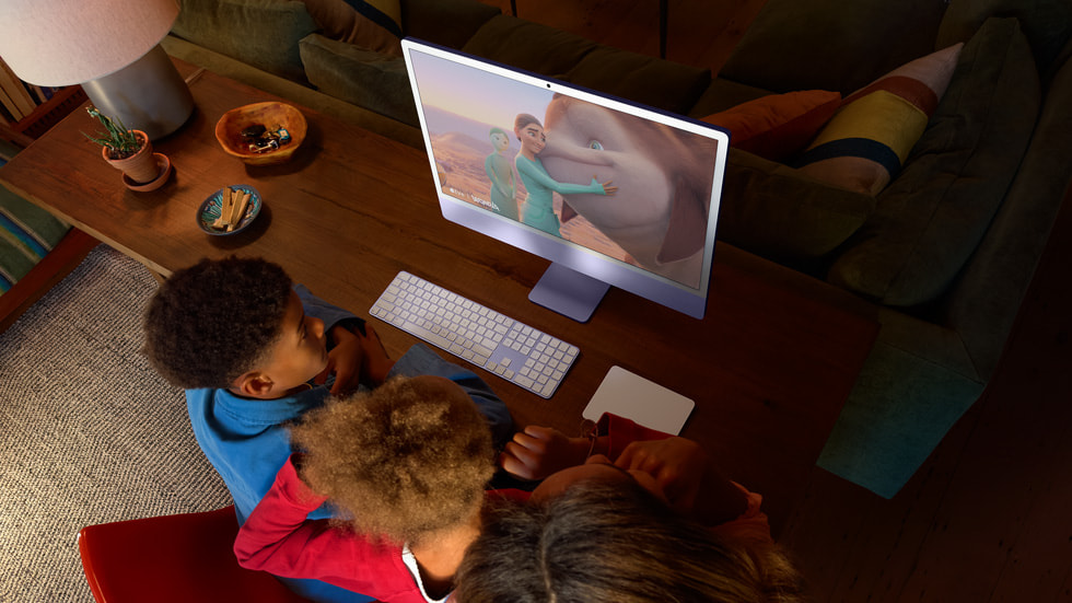 三位人士在 iMac 上觀看一幕動畫電影場景。