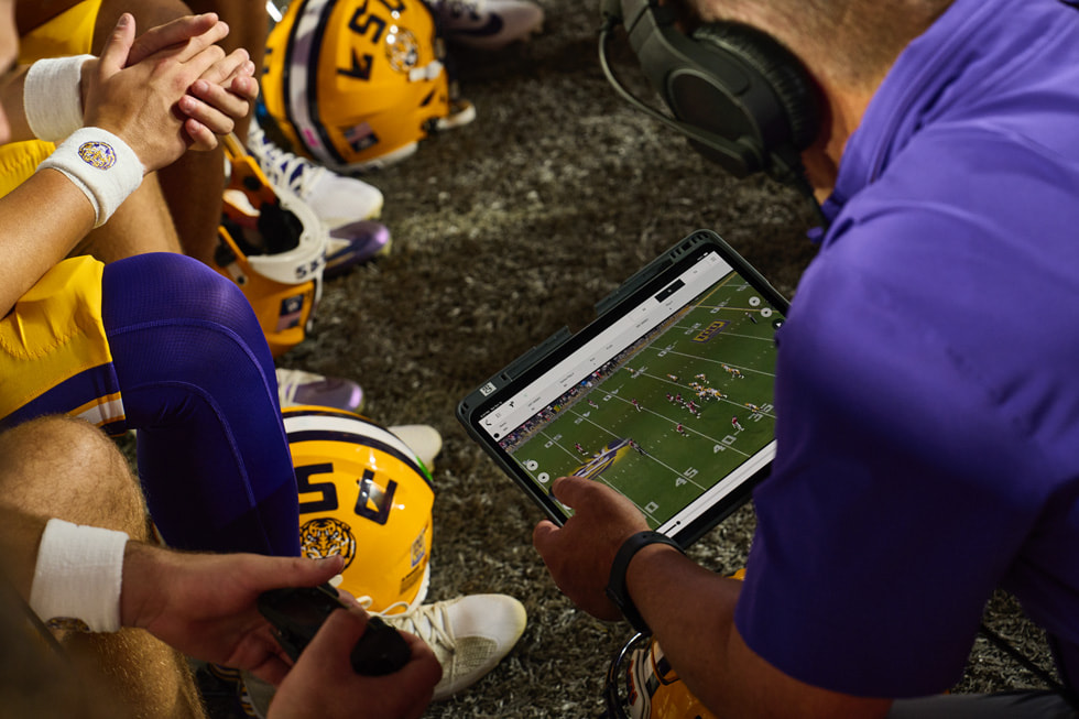 LSU 教練團和球員在美式足球比賽場邊用 iPad Pro 檢視錄影。