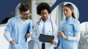 A group of healthcare workers reviewing work on a tablet