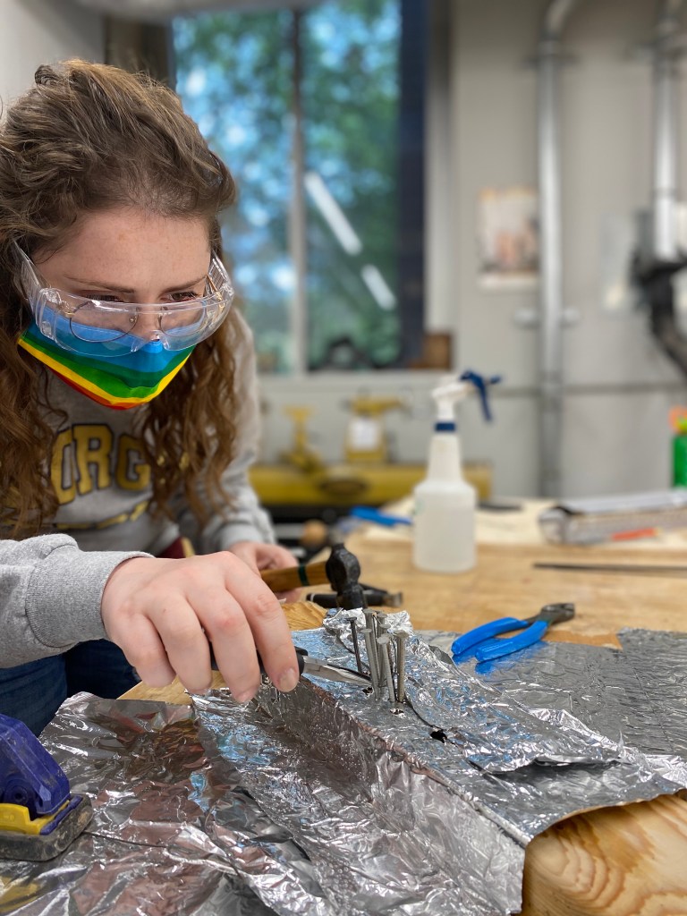 Bethe Newgent, a student at Georgia Tech in Atlanta, is extracting a shape memory alloy wire from a training rig.