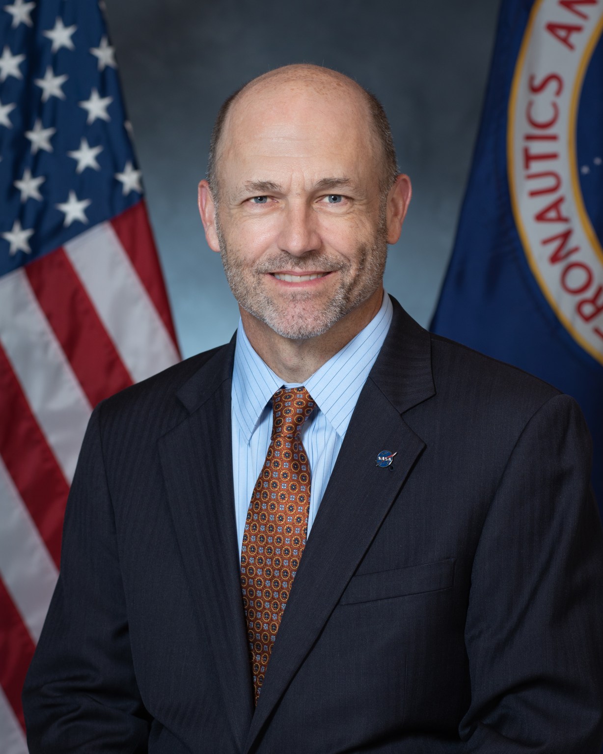 Portrait of Dr. James Kenyon with U.S. and NASA Flags in background