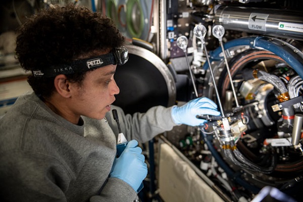 image of an astronaut setting up combustion experiment hardware