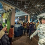 visitors smiling and taking pictures inside the NASA Glenn Visitor Center