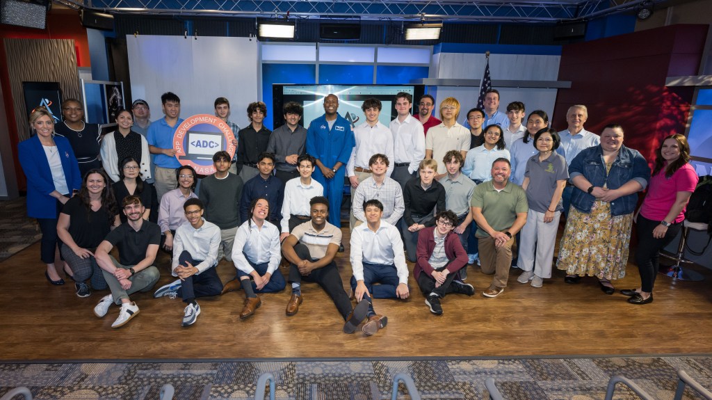 A large group of students participating in the App Development Challenge pose for a photo together