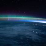 An aurora dimly intersects with Earth's airglow