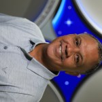 A portrait of Kennedy Space Center's Brian Smith with the Launch Services Program insignia in the background.