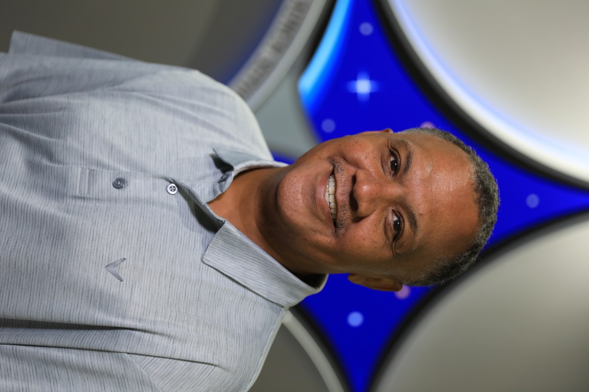 A portrait of Kennedy Space Center's Brian Smith with the Launch Services Program insignia in the background.