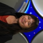 A portrait of Kennedy Space Center's Denise Pham with the Launch Services Program insignia in the background.