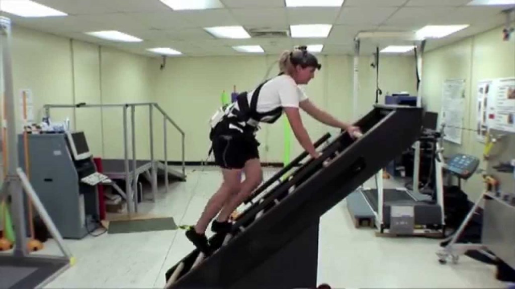 An image shows a scientist using a climbing machine to test for functional performance.