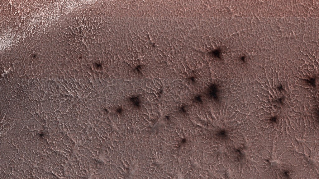 Dark splotches seen in this example of araneiform terrain captured by NASA’s Mars Reconnaissance Orbiter in 2018