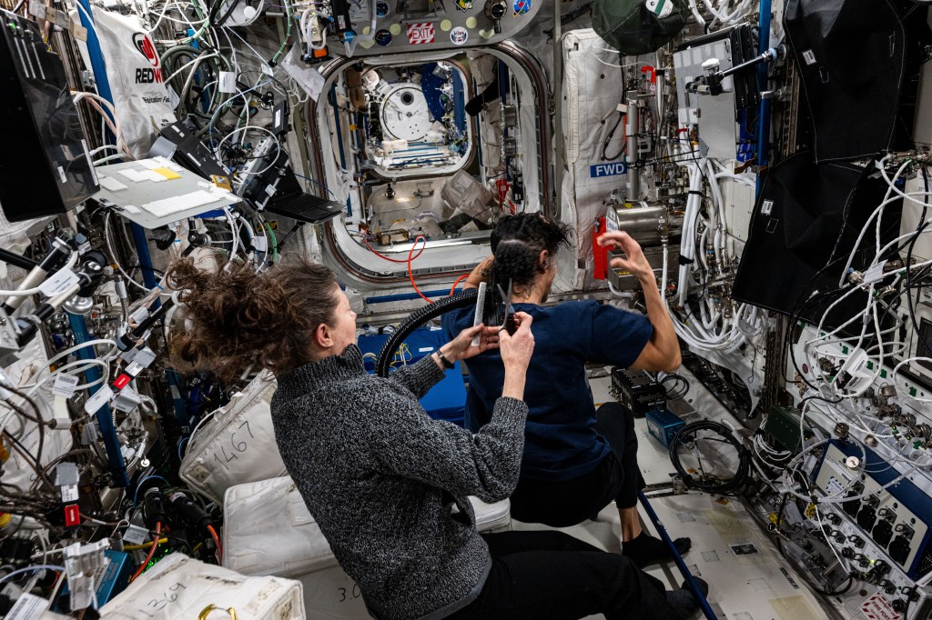 NASA astronaut Tracy C. Dyson trims NASA astronaut Suni Williams hair aboard the International Space Station's Columbus laboratory module.