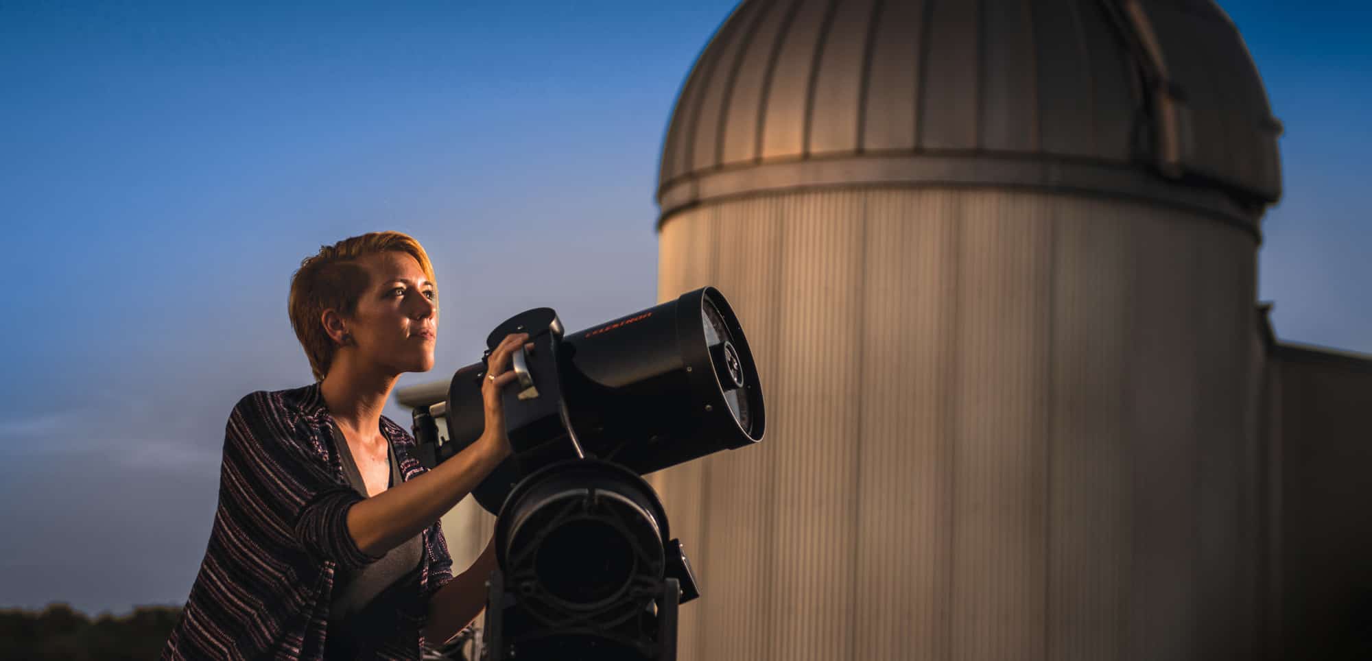 Students viewing stars through a telescope.