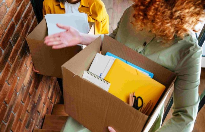 two young happy women moving to new office